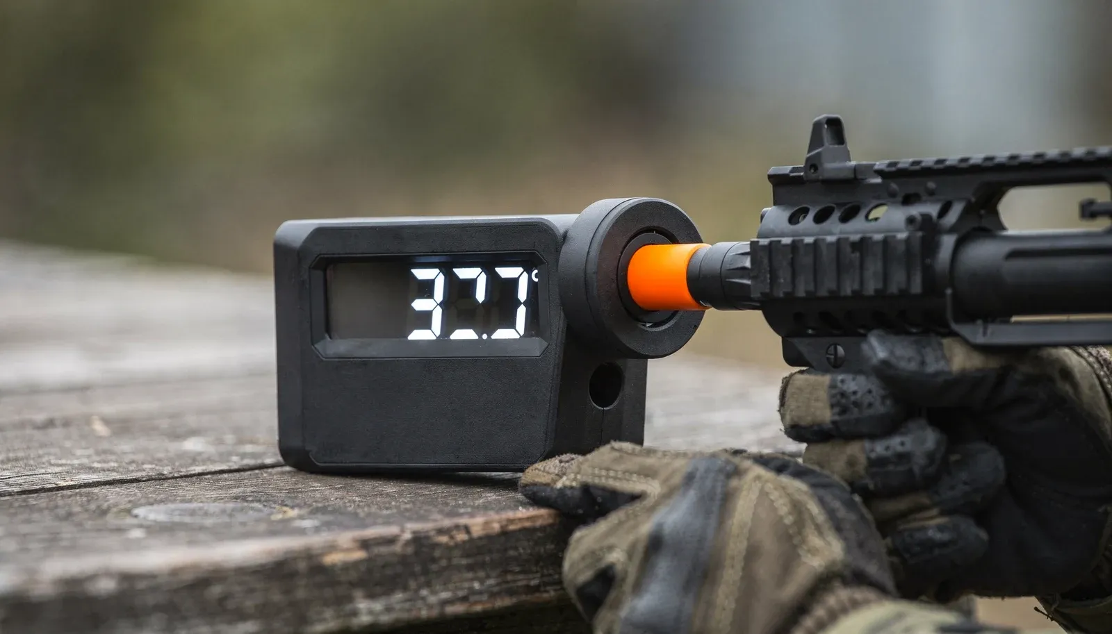 Cronógrafo digital marcando 377 FPS acoplado à ponta do cano de uma réplica de airsoft